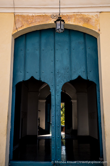 Blue wooden door with two smaller doors cut out.