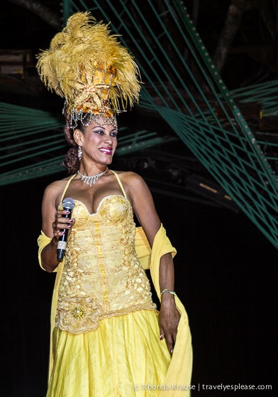 Singer in a yellow dress and feathered headdress.