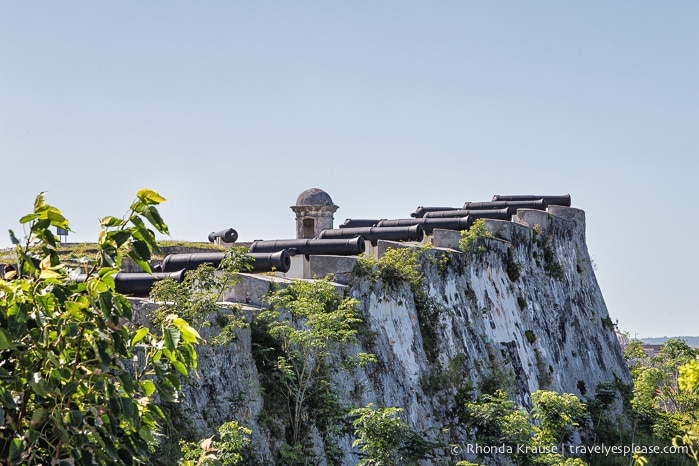 Canons pointing off a high wall of Fortaleza de San Carlos de la Caba~na.