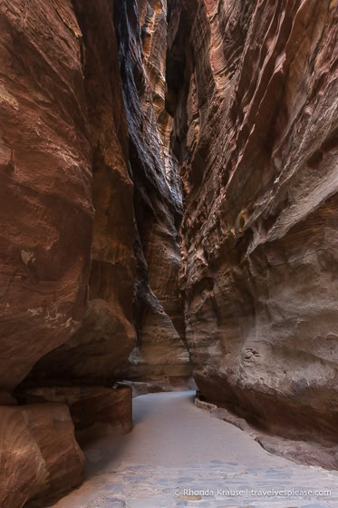 The Siq's narrow walkway between rock walls.