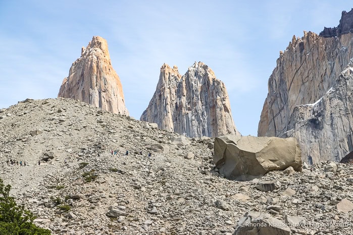 The Torres del Paine peeking up from behind a hill of rock.